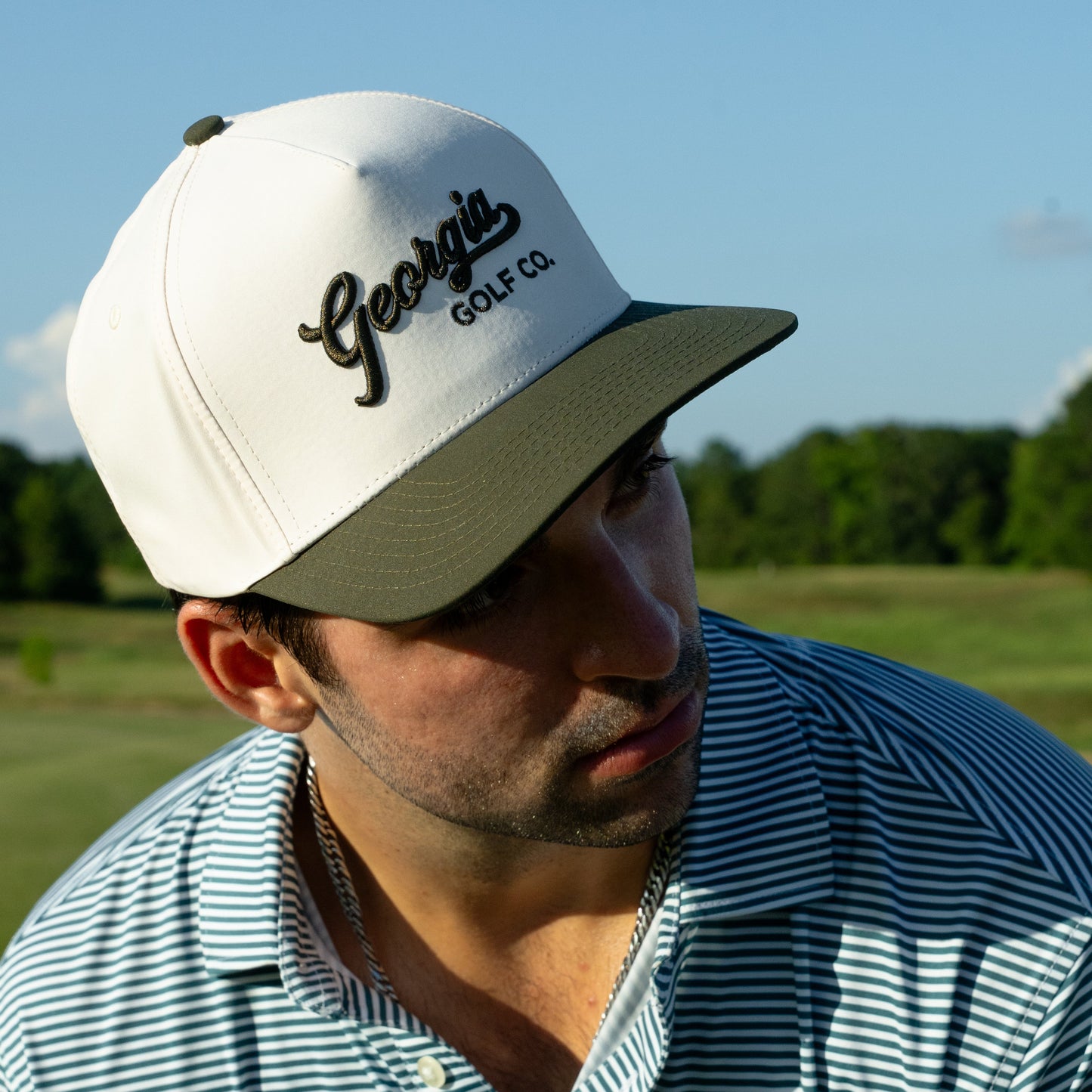 Man wearing a cap with 'Georgia' branding on a golf course